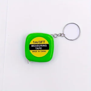 A green tape measure keychain with the words " 1 / 4 th of measuring tape ".