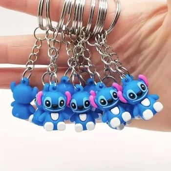 A hand holding five different stitch keychains.